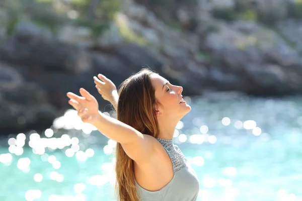 Happy woman breathing fresh air raising arms on holidays — Stock Photo, Image