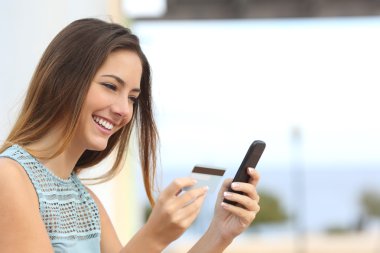 Mutlu kadın bir akıllı telefon ile online satın alma
