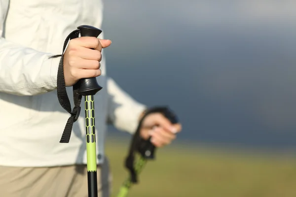 Primer plano de las manos de un excursionista caminando con postes — Foto de Stock
