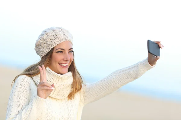 Girl taking a selfie with her smart phone in winter — Stock Photo, Image