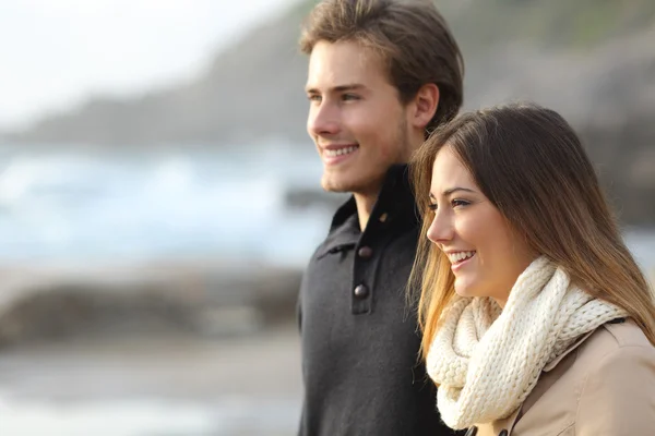 Couple in winter looking away on the beach — Stock Photo, Image