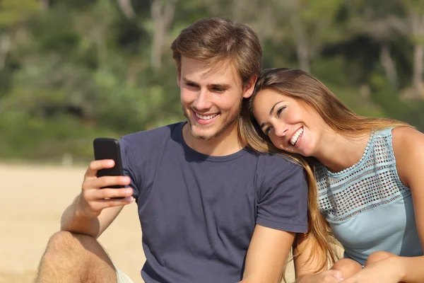 Casal adolescente compartilhando mídias sociais no telefone inteligente — Fotografia de Stock