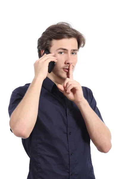Homem pedindo silêncio com o dedo nos lábios enquanto está chamando pelo telefone — Fotografia de Stock