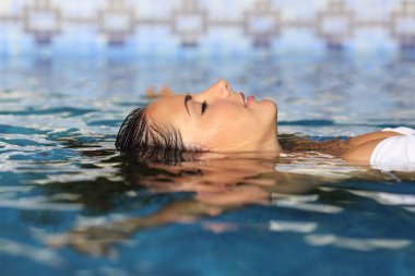 Profile of a beauty relaxed woman face floating in water clipart