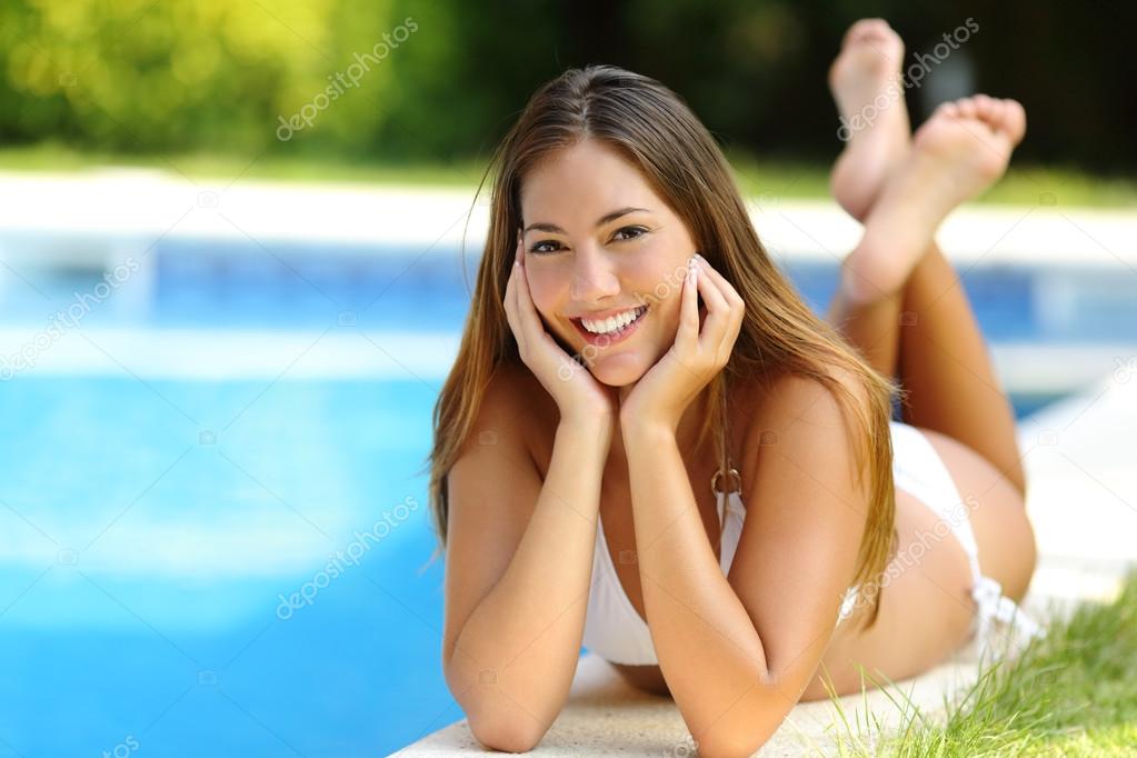 Happy girl posing wearing bikini on a pool side in summer ...
