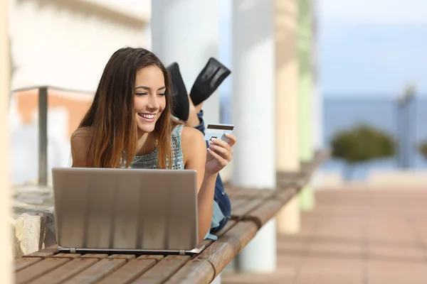 Chica casual comprar en línea con una tarjeta de crédito al aire libre —  Fotos de Stock