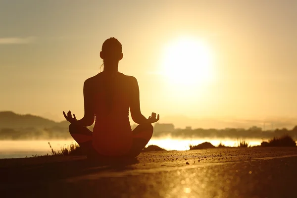 Silhouette d'une femme de fitness exerçant des exercices de méditation de yoga — Photo