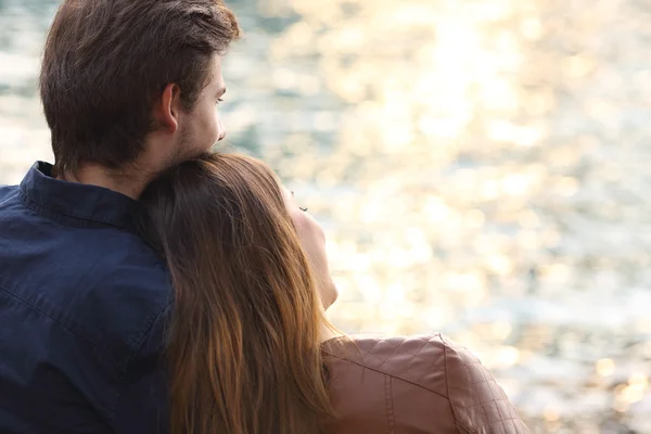 Pareja abrazando y viendo la puesta de sol en la playa — Foto de Stock