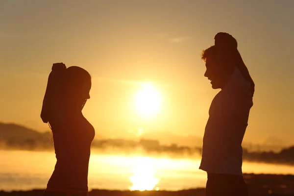Silueta fitness páru, táhnoucí se na východ slunce — Stock fotografie