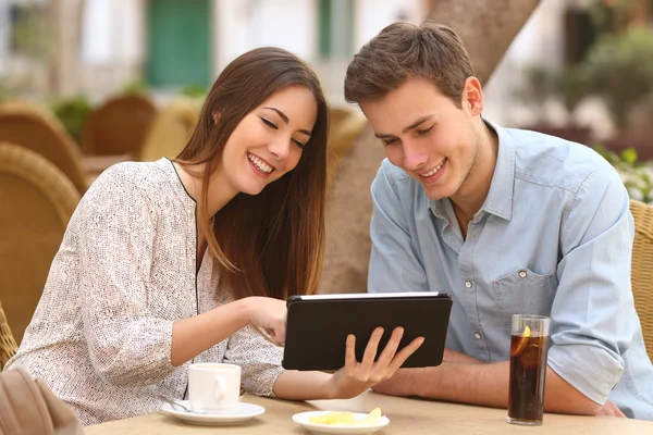 Sledování média v tabletu v restauraci pár — Stock fotografie