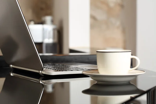 Ordenador portátil en un lugar de trabajo de mesa con una taza de café —  Fotos de Stock