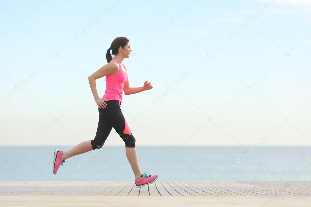 Side view of a woman running on the beach