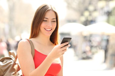 Yaz aylarında sokakta bir akıllı telefon kullanan kadın