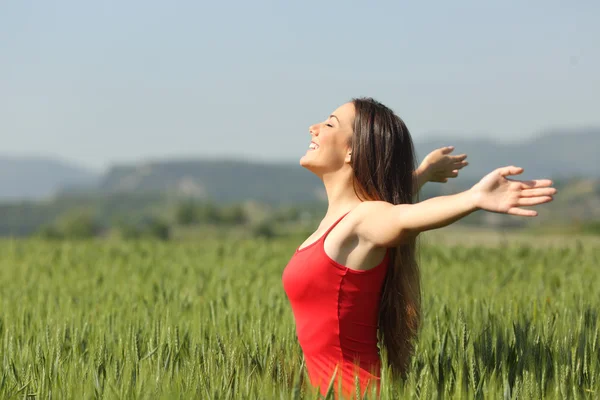 Жінка дихає глибоким свіжим повітрям у полі — стокове фото