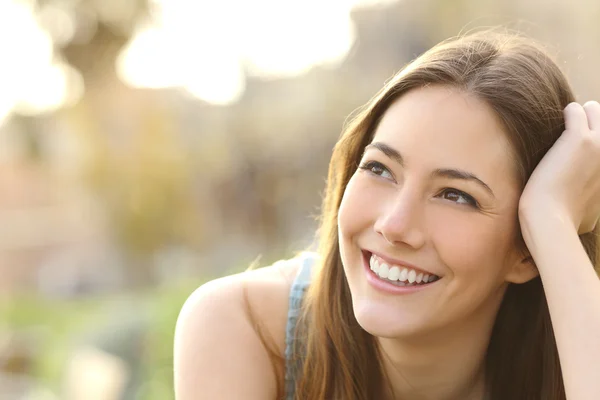 Kvinna med vita tänder tänkande och tittade åt sidan — Stockfoto