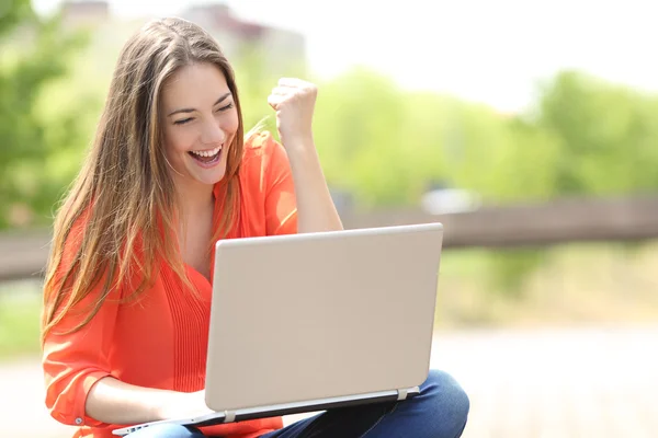 Euforisch vrouw baan met een laptop in een park zoeken — Stockfoto