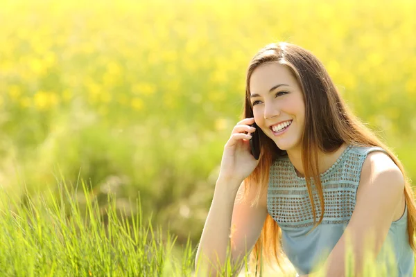 Kobieta nazywając na telefon komórkowy w zielonym polu — Zdjęcie stockowe