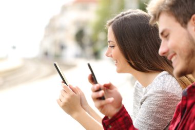 Genç çift akıllı telefonlar bir tren istasyonunda kullanma