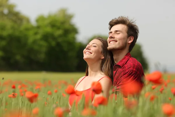 Casal abraço e respirar ar fresco em um campo vermelho — Fotografia de Stock