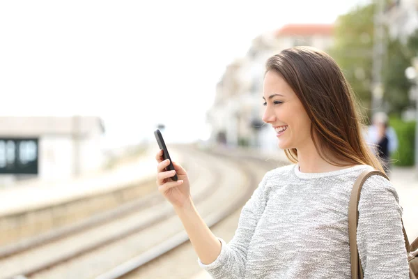 旅行者在一个火车站使用智能手机 — 图库照片