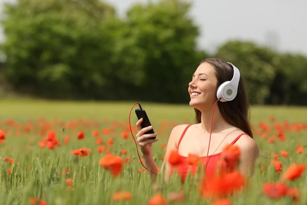 Woman breathing and listening music in a field — Stock Photo, Image