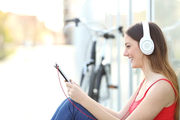 Woman listening to the music from a tablet in a park — Stock Photo, Image