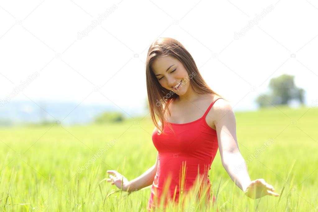 Candid girl playing with wheat in a field