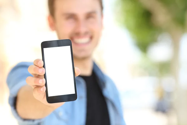 Man showing a blank phone screen in the street — Zdjęcie stockowe