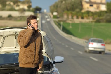 Happy man calling roadside assistance for his breakdown car clipart