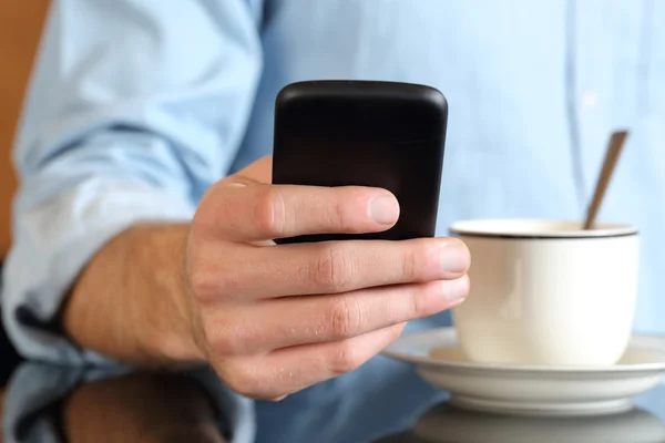 Close up of a hand using a smart phone at breakfast — Stock Photo, Image