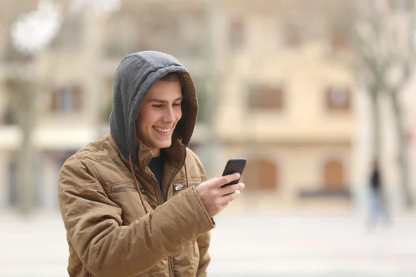 快乐的青少年行走和使用智能手机 — 图库照片