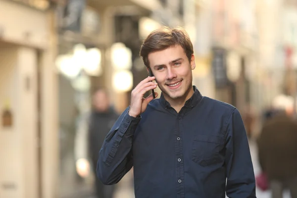 Adam sokakta yürürken telefonda arıyor — Stok fotoğraf