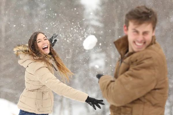 Pareja jugando con la nieve y novia lanzando una pelota — Foto de Stock