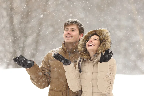 Lustiges Paar beobachtet Schnee im Winter — Stockfoto