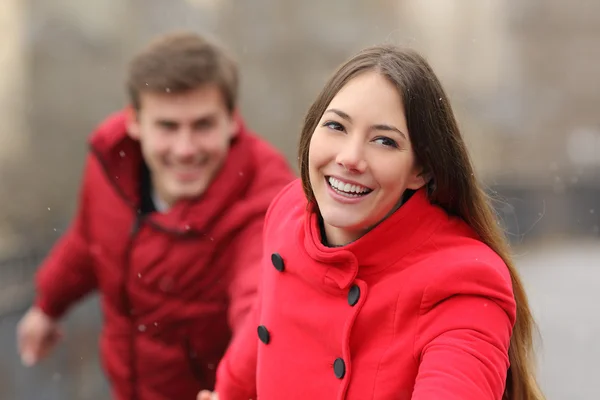 Pareja feliz corriendo hacia la cámara en invierno — Foto de Stock