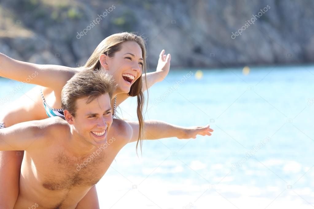 Happy couple playing on the beach
