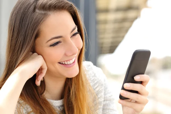 Mujer navegando medios de comunicación en un teléfono móvil —  Fotos de Stock