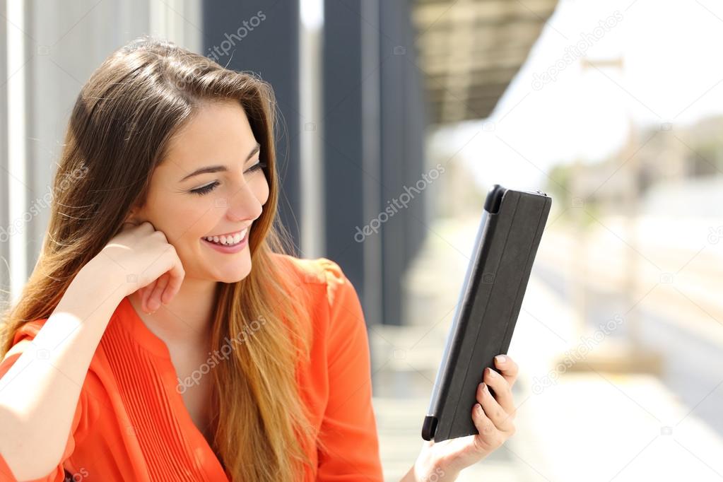 Woman reading a Tablet or ebook in a train station