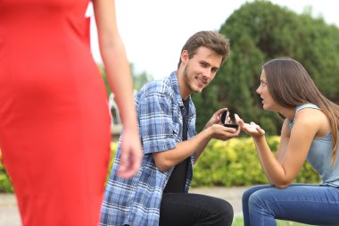 Unfaithful man looking another girl during proposal clipart