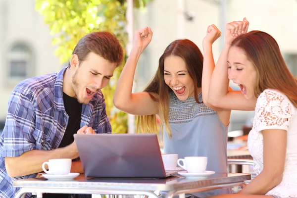 Amigos dando un regalo portátil a una chica sorprendida —  Fotos de Stock