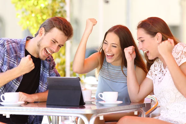 Euphoric winner friends using a with a tablet — Stock Photo, Image