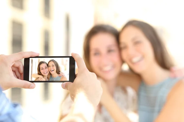 Amigos tomando fotos con un teléfono inteligente — Foto de Stock