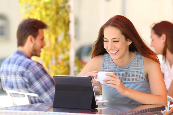 Boldog asszony nézi a videókat egy tabletta, egy kávézóban — Stock Fotó
