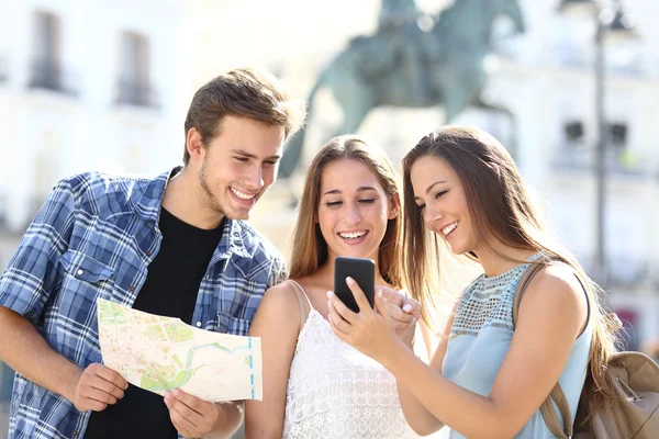 Tre turister vänner consulting gps på smart telefon — Stockfoto