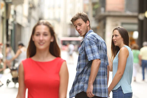 Disloyal man with his girlfriend looking at another girl — Stock Photo, Image