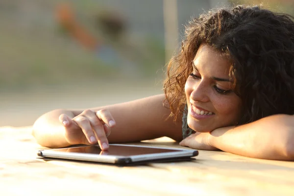 Mujer usando una tableta tocando la pantalla al atardecer — Foto de Stock