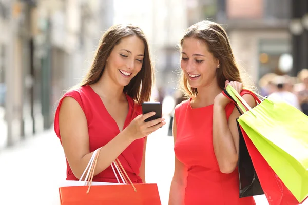 Dois compradores de moda fazendo compras com um telefone inteligente — Fotografia de Stock