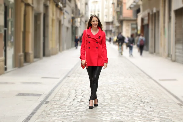 Fashion woman in red walking on a city street — Stockfoto