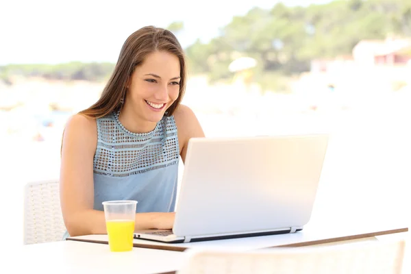 Girl using a laptop on summer vacation — Stockfoto
