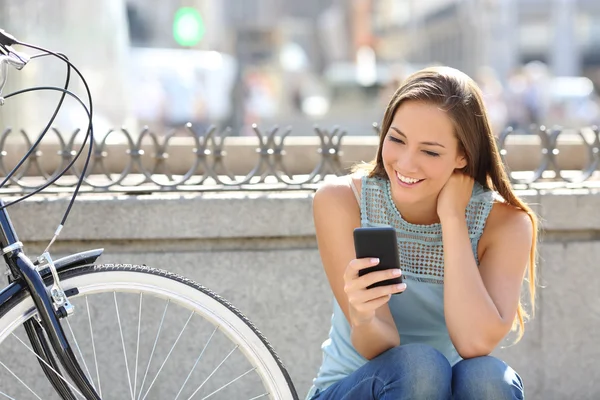 Chica feliz viendo los medios de comunicación en un teléfono inteligente — Foto de Stock